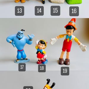 May include: A collection of 10 small plastic Disney character figurines. The characters include Beast, Captain Hook,  a green-clad dwarf, a raccoon, Genie, Pinocchio, Peter Pan, Pluto, and a yellow dog.
