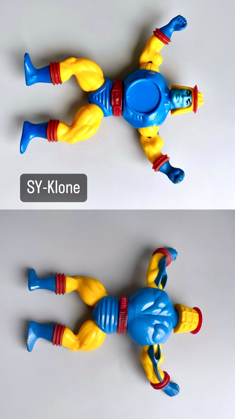 May include: A blue and yellow action figure with a red and yellow helmet. The figure is lying on its back with its arms outstretched. The figure is labeled "SY-Klone".