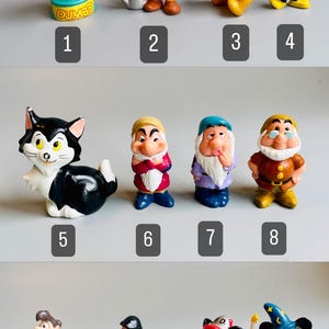 May include: A set of 12 Disney character figurines, including Dumbo, Snow White's dwarfs, Mickey Mouse, Winnie the Pooh, and more. The figurines are made of plastic and are painted in bright colors.