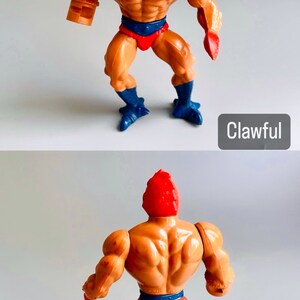 May include: Clawful, a vintage He-Man action figure with a red and orange head, orange body, red loincloth, and blue feet. The figure is posed in a standing position with arms outstretched.