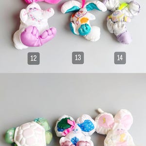 Pu&ograve; includere: Una collezione di peluche a forma di animali, tra cui conigli, una tartaruga e un topo. I giocattoli sono bianchi con accenti colorati in rosa, blu, verde e viola. Ogni giocattolo ha un design unico ed &egrave; numerato da 12 a 17.