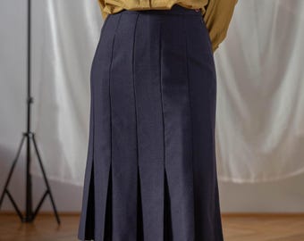 May include: A navy blue pleated skirt with a straight silhouette. The skirt is knee-length and has a simple design.