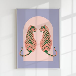 May include: Framed art print showing two stylized tigers facing each other. The tigers have pink bodies with green stripes, set against a light pink arch and a lavender background. The artwork is in a minimalist style.