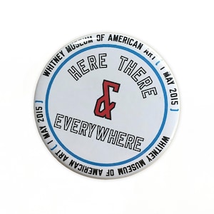 Peut inclure: Un bouton rond blanc avec le texte "HERE THERE & EVERYWHERE" en noir, avec un esperluette rouge. Le bouton comprend également le texte "WHITNEY MUSEUM OF AMERICAN ART I MAY 2015" dans un cercle bleu sur le bord.