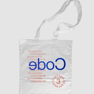 Peut inclure: Sac fourre-tout blanc avec du texte bleu qui dit "Code" et du texte marron qui dit "Art Days of 3". Le sac a un hashtag bleu et marron avec le texte "#codeartfair codeartfair.dk @codeartfair codeartfair.dk".