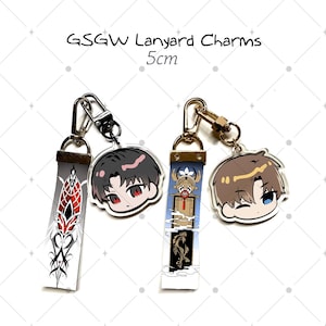 May include: Two GSGW Lanyard Charms measuring 5cm, each featuring a fabric strap and an acrylic character pendant. One set has a black-haired character with red eyes and a red tribal strap, the other a brown-haired character with a blue-themed strap.