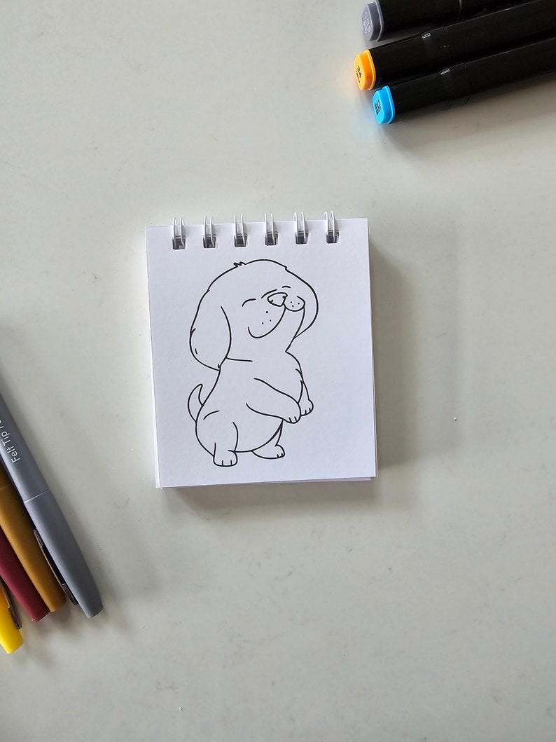 May include: A black and white line drawing of a dog on a white sheet of paper in a spiral bound notebook.