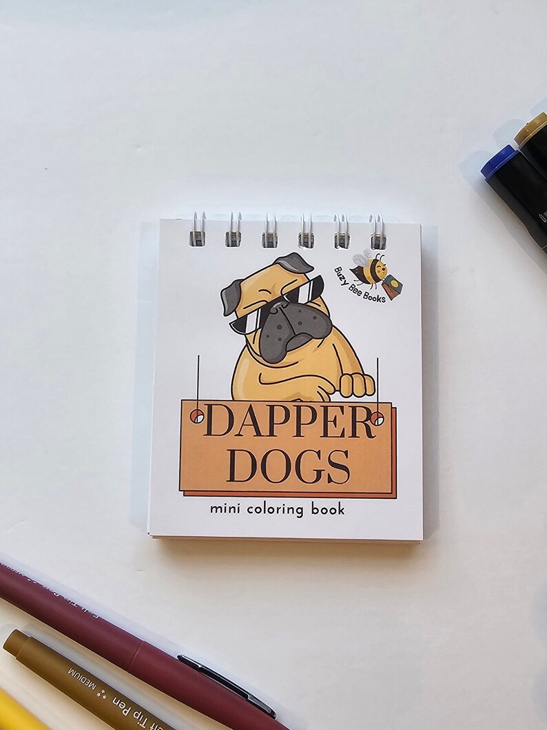 May include: A mini coloring book with a cartoon pug wearing sunglasses and a sign that says "Dapper Dogs" with the text "mini coloring book" below. The book cover is white with a yellow bee logo that says "Busy Bee Books".
