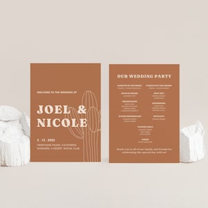 Peut inclure: Deux cartes brunes avec du texte blanc. La carte de gauche présente une illustration de cactus et indique "Bienvenue au mariage de Joel & Nicole" et "3.12.2022" avec l'emplacement "Twentynine Palms, Californie" et "Nowhere: A Desert Social Club". La carte de droite indique "Notre fête de mariage" et énumère les noms des membres de la fête de mariage.