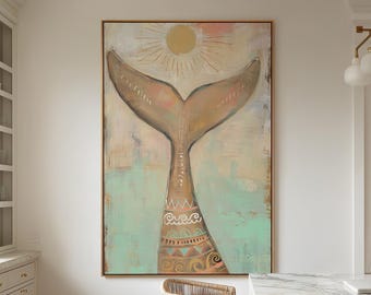 Op de afbeelding: Groot ingelijst kunstwerk met een walvisstaartontwerp en een zon op de achtergrond. Het kunstwerk heeft een gouden lijst en is geschilderd in tinten beige, perzik en turquoise. Rotan barkrukken staan op de voorgrond.