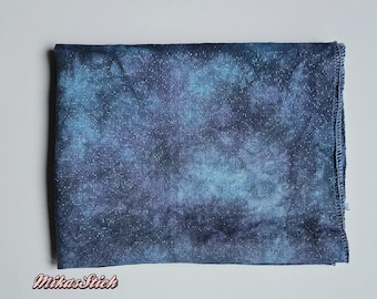 Puede incluir: Una tela azul y morada con efecto tie-dye y un brillo sutil. La tela es suave, texturizada y perfecta para proyectos de manualidades.