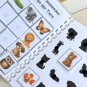 May include: A children's matching game with animal illustrations and their corresponding shadows. The game features a variety of animals, including a caterpillar, elephant, butterfly, lion, puppy, owl, clownfish, and tiger.