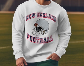 May include: White sweatshirt with a vintage-style graphic of a football helmet and the text "NEW ENGLAND FOOTBALL".