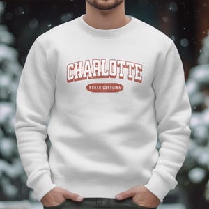 White sweatshirt with "Charlotte North Carolina" text.