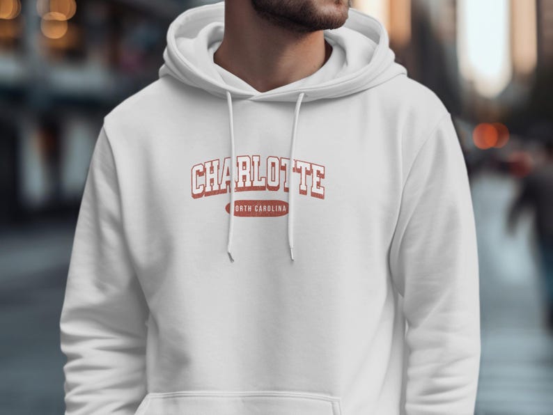 White hoodie with "Charlotte North Carolina" text on chest.