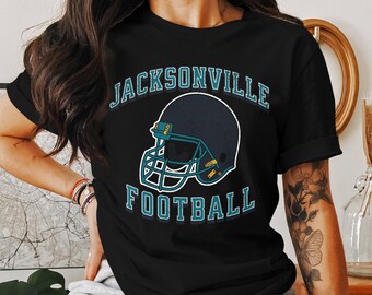May include: Black t-shirt with a teal and white graphic of a football helmet and the text "JACKSONVILLE FOOTBALL".