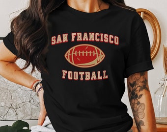 May include: Black t-shirt with a gold and red graphic of a football and the text "SAN FRANCISCO FOOTBALL".