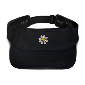 May include: Black visor with a white daisy embroidered on the front. The daisy has a yellow center and purple accents.