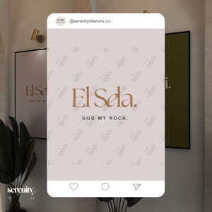 May include: A social media post with a light gray background featuring a logo for "El Sela" with the text "God My Rock." The logo is a brown stylized font with a pattern of small hand-drawn icons in the background. The post is from the account "@serenityinteriors.co".