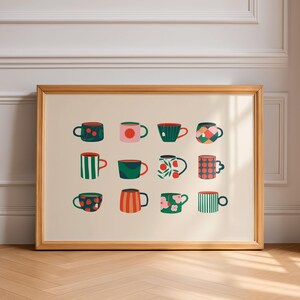 May include: A framed print featuring twelve colorful mugs with various patterns. The mugs are arranged in three rows of four, each with a unique design, including polka dots, stripes, and floral motifs. The frame is a light wood color, and the background is a neutral beige.