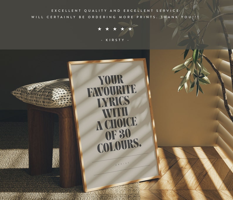 May include: A framed print with the text "YOUR FAVOURITE LYRICS WITH A CHOICE OF 30 COLOURS." The print has a gold frame and is displayed on a wooden bench. The background includes a pillow and a wall with sunlight streaming through blinds.