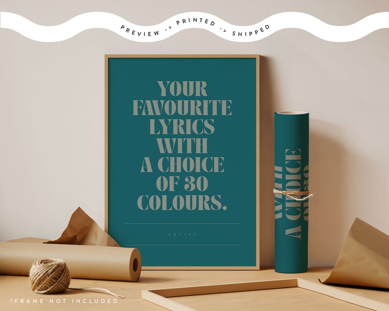 May include: A framed teal print with the text "YOUR FAVOURITE LYRICS WITH A CHOICE OF 30 COLOURS." A rolled teal poster with text is next to the framed print. Brown paper and twine are also in the image.