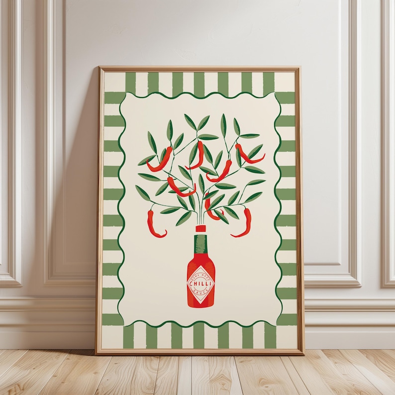 May include: A framed art print featuring a red chili pepper illustration. The artwork depicts a bottle with the word "CHILLI" and a tree-like arrangement of red chili peppers and green leaves. The border has a green and white striped pattern.