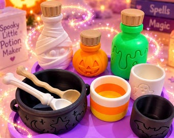 Puede incluir: Un set temático de Halloween que incluye un caldero negro con símbolos celestiales, dos cucharas con forma de hueso, una botella de momia, una botella de calabaza, una botella de slime verde, un vaso de caramelo, un vaso de fantasma y un vaso de murciélago sobre una bandeja morada.