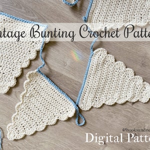 May include: A crochet bunting pattern with a vintage design. The bunting is made of cream colored yarn with a blue trim. The pattern is available as a digital download. The text "Vintage Bunting Crochet Pattern" and "Digital Pattern" are visible in the image.