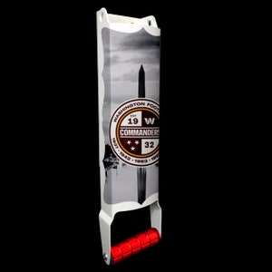 May include: White metal roller with a red handle. The roller features a graphic of the Washington Commanders logo and a black and white image of the Washington Monument.
