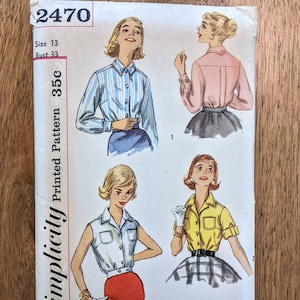 Könnte beinhalten: Vintage Simplicity Schnittmuster Nummer 2470, Größe 13, Brustumfang 84 cm, gedrucktes Muster 35c. Das Muster zeigt drei verschiedene Stile von Blusen mit langen und kurzen Ärmeln sowie eine ärmellose Option. Das Muster ist mit "Einfach zu machen" gekennzeichnet.