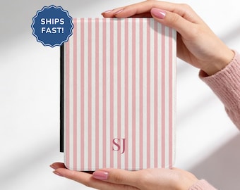 May include: A rectangular electronic reader case featuring a vertical light pink and white striped pattern. The centre of the front cover displays the monogram SJ in a dark pink serif font. The case has a black spine and a textured finish.