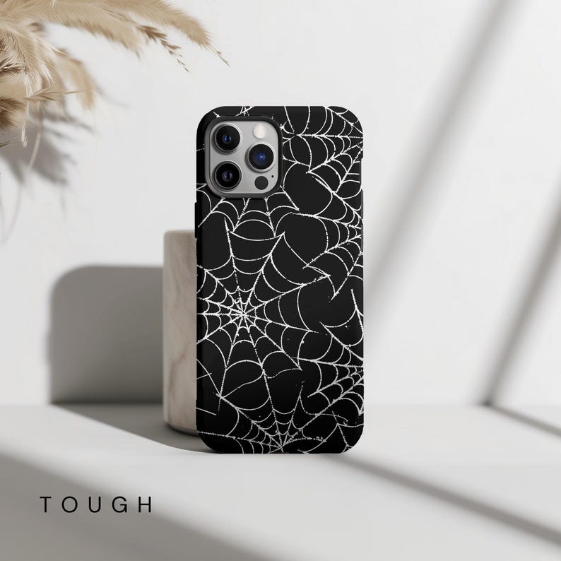 May include: Black phone case with a white spiderweb pattern.
