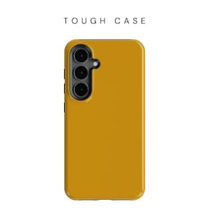 May include: Mustard yellow phone case with a triple-lens camera cutout. The case has a smooth finish and the text "TOUGH CASE" is printed at the top. The phone case is designed to protect the phone.