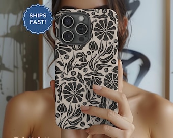 May include: A black and white floral phone case for an iPhone with a camera lens cutout. The case has a cream background with black floral designs.