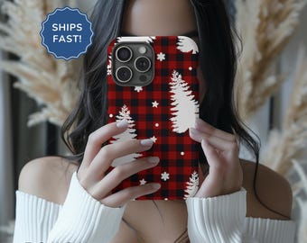 May include: A red and black checked phone case with white Christmas trees and snowflakes. The case is designed for an iPhone.