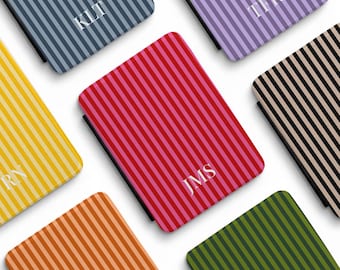 May include: Six rectangular cases featuring vertical stripes in blue, purple, yellow, red, black, and orange. Each case displays a white monogram: KLT, TFR, RN, JMS, and the text AMORE CASES. The cases have a smooth, uniform finish.