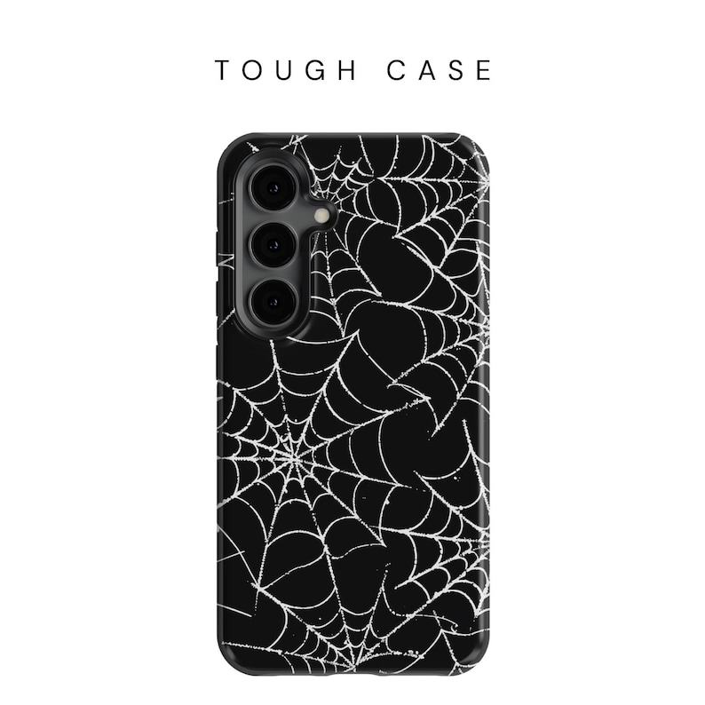 May include: Black phone case with a white spiderweb design. The case has a raised camera bump and a cutout for the phone's buttons.