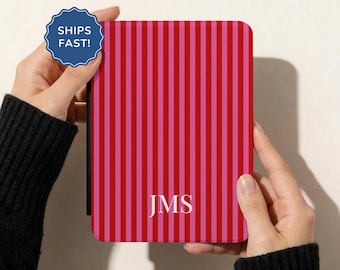 May include: A rectangular e-reader case featuring a vertical striped pattern in alternating shades of red and pink. The centre of the case displays the white capital letters JMS in a serif font. The case has a black spine on the left side.