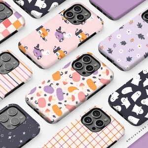 May include: A collection of phone cases with various Halloween-themed designs. Patterns include ghosts, pumpkins, witch characters, and floral motifs. The cases feature a variety of colors, including pink, purple, orange, and white. The cases are for a smartphone.