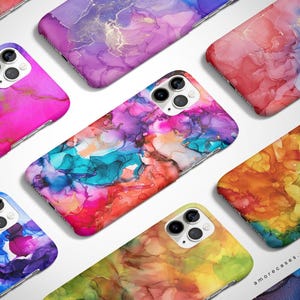 May include: A set of colorful phone cases with abstract designs. The cases feature a variety of colors, including pink, blue, green, yellow, and orange. The designs are reminiscent of alcohol ink art.