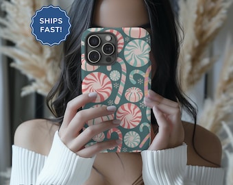 May include: A teal phone case with a pattern of red and white candy canes and peppermint swirls. The case is designed for an iPhone.
