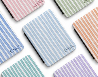 May include: A collection of rectangular e-reader cases featuring vertical striped patterns in various pastel colours including pink, green, blue, orange, and purple. Some cases are personalised with names like Amelia, Chloe, Grace, and Olivia.