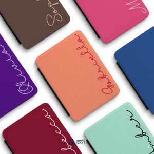 May include: A collection of rectangular tablet cases in various solid colors including brown, pink, dark blue, purple, orange, maroon, and mint green. Each case features a personalized name written in a cursive script font along the side.