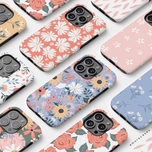 May include: A collection of phone cases featuring various floral patterns. The cases are designed for a smartphone with a camera bump. The patterns include pink and white flowers, blue and white flowers, red and white roses, and more. The cases are all made of a durable material and are designed to protect your phone from scratches and drops.