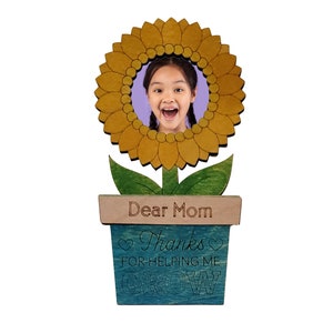 May include: A wooden sunflower photo frame with a blue and green pot. The pot has the text "Dear Mom Thanks for helping me grow" on it.