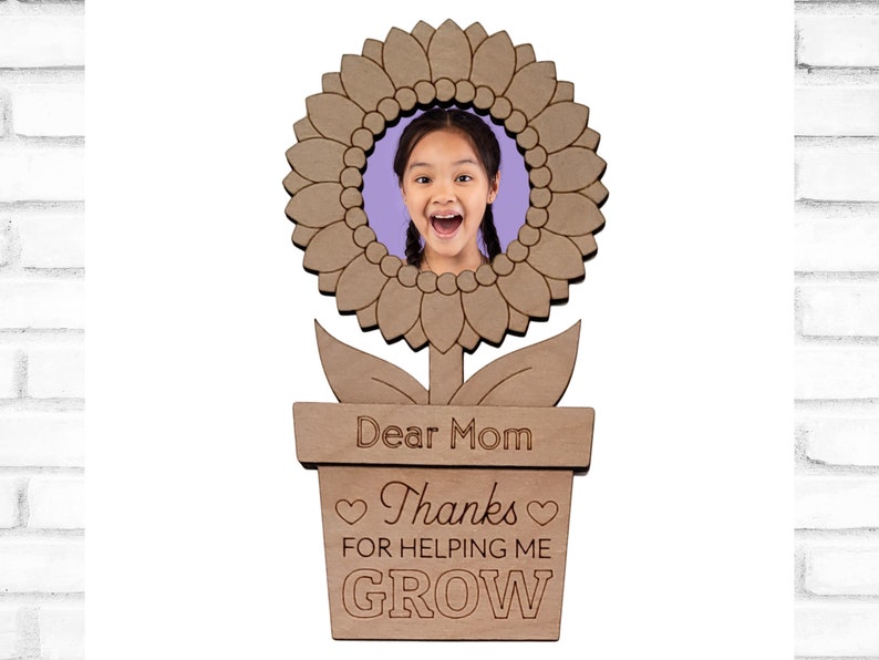 May include: Wooden photo frame shaped like a sunflower with a pot and the text "Dear Mom Thanks for helping me GROW".
