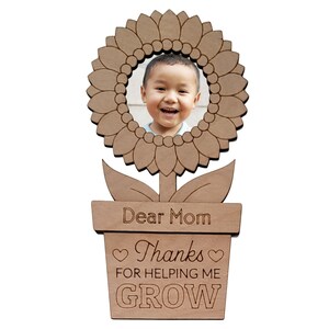 May include: Wooden photo frame shaped like a sunflower with a pot and the text "Dear Mom Thanks for helping me GROW".