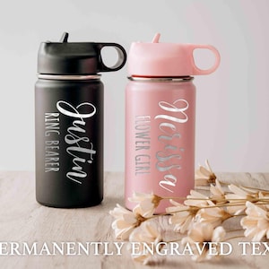 May include: Two personalized water bottles with engraved names. The black bottle says "Justin" and "Ring Bearer". The pink bottle says "Melissa" and "Flower Girl".