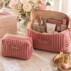 a pink makeup bag with a name tag, containing various makeup products, placed on a table alongside a bouquet of flowers and a card.